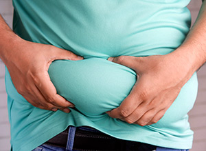 manos apretando barriga